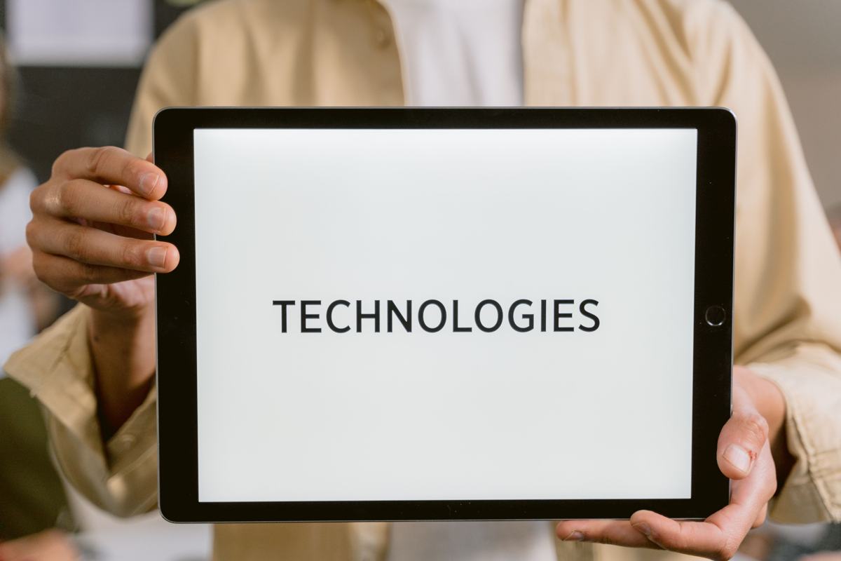 A trainer holding a tablet that says TECHNOLOGIES